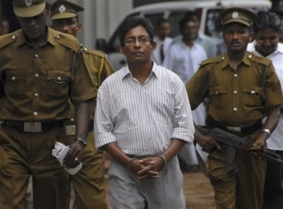  AFP – Sri Lankan prison officials escort Tamil journalist J. S. Tissainayagam to a prison bus. Tissainayagam, … 