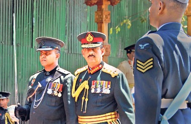 In an area enclosed by tarpaulin, General Fonseka inspecting his last military guard of honour as the Chief of Defence Staff on Monday. Pic by Sanka Vidanagama