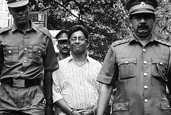Journalist J.S. Tissanayagam, who wrote articles critical of a military offensive against the Tamil Tigers, is escorted by prison officials in Colombo on Aug. 31. He has been sentenced to 20 years'  -  Reuters