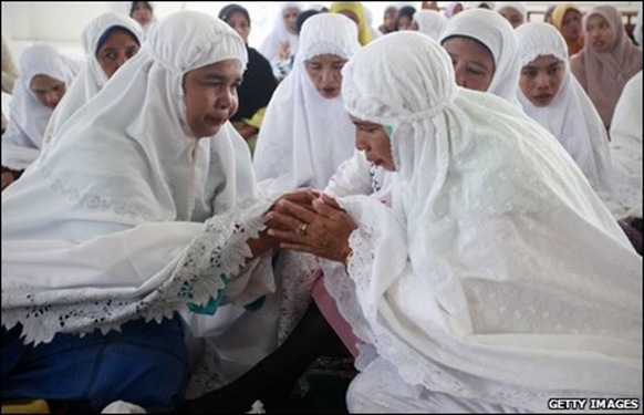 Women console each other at prayer services in Aceh's mosques
