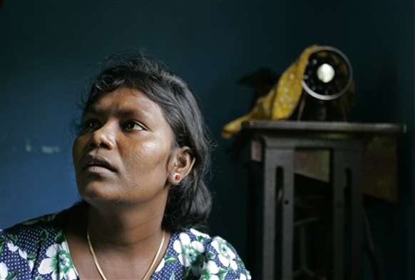This Nov. 13, 2009 photo shows Vairamutto Bavani looking on with her sewing machine seen in the background of her house in Kalkudah, about 230 kilometers (143 miles) north east of Colombo, Sri Lanka. Three years ago, Bavani left her home in eastern Sri Lanka to attend her cousin's wedding in the north. Bavani lost six members of her family and both her legs to a bomb and spent months detained in an overcrowded refugee camp before finally returning home. Bavani is one of tens of thousands of refugees who are struggling to rebuild their lives in post-war Sri Lanka, often under tight control from the government. During the final months of the war, nearly 300,000 mostly Tamil civilians were trapped between rebels and advancing government troops, and these refugees are now in various stages of limbo. (AP Photo/Eranga Jayawardena)