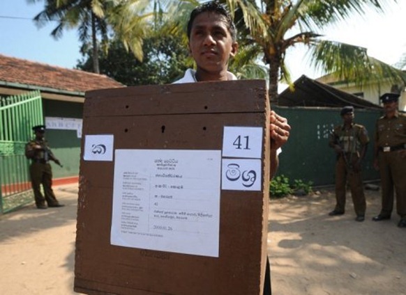 A Sri Lankan election worker carries ballot boxes in Colombo ahead of the island state's presidential election