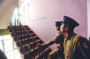 Policemen stand guard in the stairwell of the pro-opposition Lanka newspaper offices in Delkanda, a Colombo suburb, yesterday