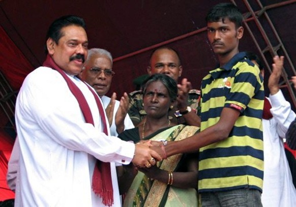 Sri Lankan President Mahinda Rajapakse (L) officially frees an unidentified former Tamil Tiger combatant