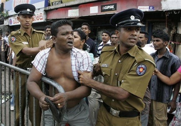 Sri Lankan police officers detain an opposition protester during a protest in Maharagama, on the outskirts of the capital Colombo, Sri Lanka, Thursday, Feb. 11, 2010. Sri Lanka's defeated presidential candidate and the former army chief Gen. Sarath Fonseka appealed for calm after violence broke out following his arrest. (AP Photo-Chamila Karunaratne)