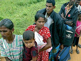 Internally displaced Sri Lankan ethnic Tamil civilians stand in a line to get into the government controlled area in Riditenne, about 250 kilometers (156 miles) east of Colombo, Sri Lanka , Monday, Dec. 18, 2006. Hundreds of Tamil civilians fled Tamil Tiger rebel held areas and entered government controlled territory fearing escalation of violence. (AP Photo/Eranga Jayawardena)