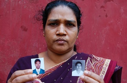 Samsun Nihara shows photographs of her missing son and husband. Photo: Matt Wade