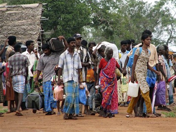 Internally displaced Sri Lankan ethnic Tamil refugees come out of camps for displaced in Manik Farm, Sri Lanka, Tuesday, Dec. 1, 2009. Sri Lanka on Tuesday allowed nearly 127,000 Tamil refugees to leave squalid and overrun government camps where they have been detained since the country's civil war ended six months ago, an official said. (AP Photo/Sanath Priyantha)