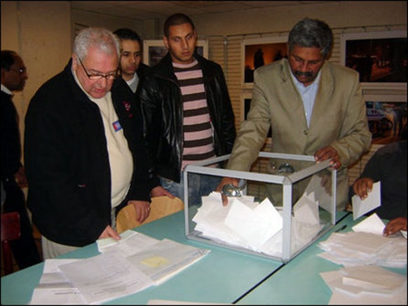 Mr. Thiruchothy, one of the organisers of the poll at a polling station with election officials before the counting starts