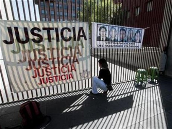 A woman puts up a banner next to pictures of Mexican students killed in Ecuador when the Colombian government attacked a guerrilla camp there on March 2, 2008, during a protest outside the foreign ministry in Mexico City March 2, 2009. Credit: Reuters - Henry Romero