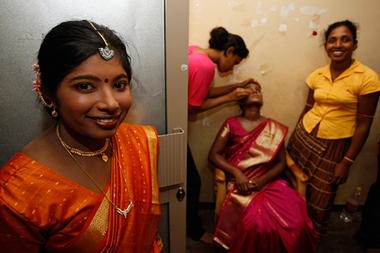 A former female Tamil Tiger rebel dressed in bridal attire looks on as others dress up another bride during a mass wedding ceremony at a government rehabilitation camp near Vavuniya in northern Sri Lanka in June.  Eranga Jayawardena AP