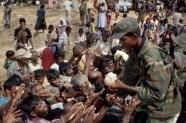 A Sri Lankan soldier hands out food to Tamils