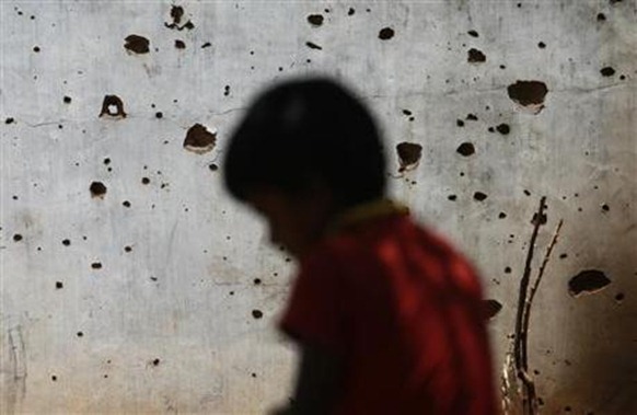 A resettled Tamil sits next to his house, which was damaged from the war between Liberation Tigers of Tamil Eelam (LTTE) and the government, in Vavuniya, about 260 km (161 miles) from Colombo, August 14, 2010. REUTERS Dinuka Liyanawatte