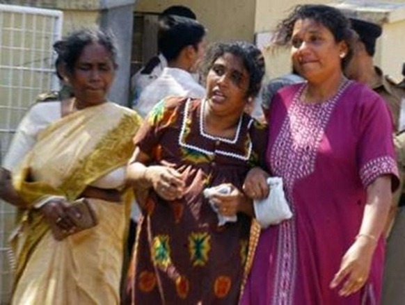 Relatives react after identifying the bodies of slain workers from the international aid agency Action Contre La Faim (ACF), at a hospital entrance in Trincomalee, August 8, 2006. (REUTERS)