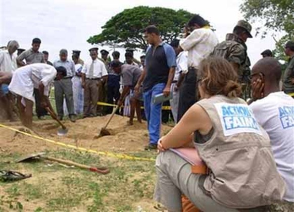 Representatives of international relief agency Action Against Hunger, right, look on as workers exhume the remains of one of 17 aid workers. (Photo:AP)