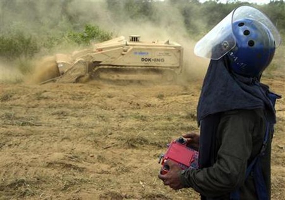 A de-miner uses a remote control to guide a de-mining machine in the Wanni area, north of Vavuniya and 254 km (158 miles) north of Colombo, May 17, 2010. Credit: Reuters Stringer