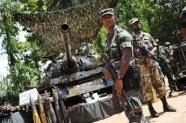 Sri Lankan soldiers stand guard next to a tank which was captured by the army from the LTTE (AFP File, Pedro Ugarte)