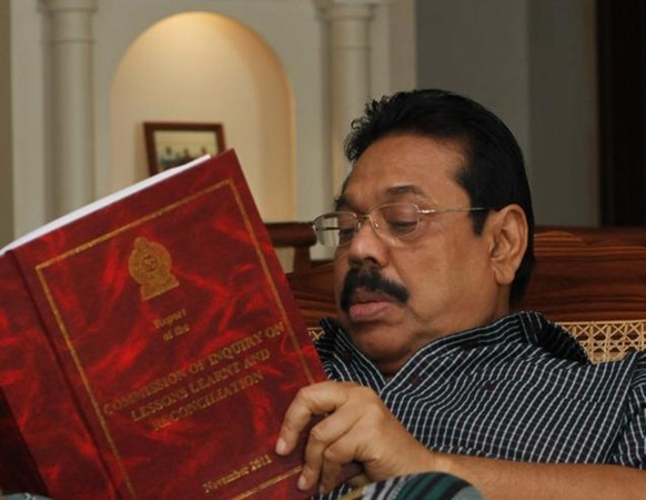 AP In this file photo, Sri Lankan President Mahinda Rajapaksa goes through the Lessons Learnt and Reconciliation Commission report, that investigated alleged wartime abuses during the country's civil war, in Colombo. 