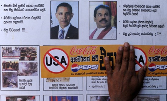 AHRC Photo: A Buddhist monk holds a sticker calling for the boycott of U.S products in Colombo March 23, 2012.)