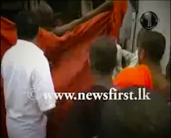 A Buddhist monk flashes a mosque in Dambulla. Screen grab from News 1st TV footage. 