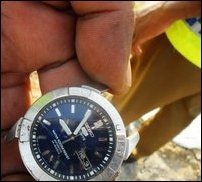 An SL police officer holding the wristwatch of the slain victim