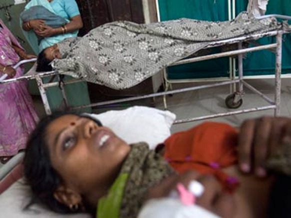 A woman who has just given birth looks at another woman in labour. Reuters