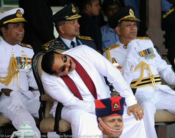 Sri Lankan President Mahinda Rajapaksa bends to catch a glimpse of sky divers in Colombo. Ishara S.Kodikara / AFP/Getty Images 