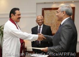 President Mahinda Rajapakse (left) shakes hands with Mohan Peiris after appointing him chief justice on January 15 (Sri Lankan President's Office/AFP/File)