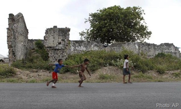 In this July 25, 2011 photo, Sri Lankan ethnic Tamil children play in front of a war damaged building in Jaffna. Photo: AP 