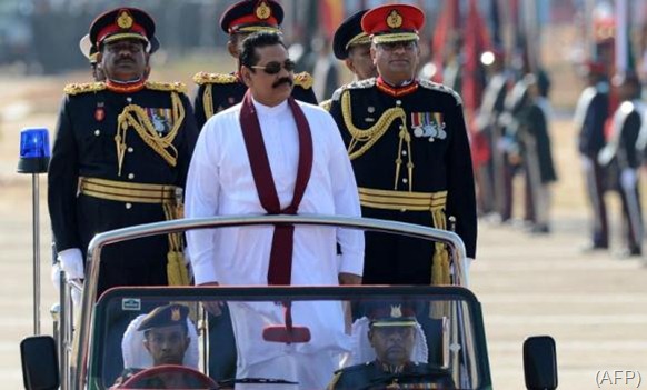 Sri Lanka President Mahinda Rajapaksa looks on as he rides in a vehicle during a Victory Day parade in southern town of Matara. (AFP)